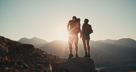 Travelers, man and a woman with backpack standing on the stone of mountain , holding hands and...