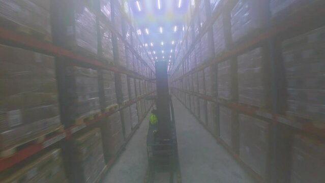 Forklift Driving Between The Rack Of Frozen Food Stored Inside Cold Storage Warehouse. - aerial fpv 