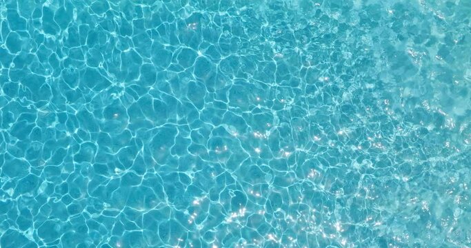 Blue water in the swimming pool with light reflections.