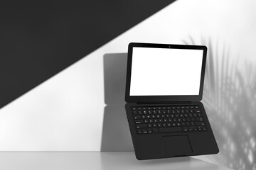Modern Laptop Computer Notebook with Blank Screen for Your Design on a White Product Presentation Podium Cube. 3d Rendering