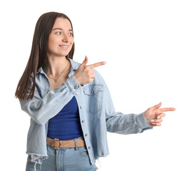 Young woman in shirt pointing at something on white background