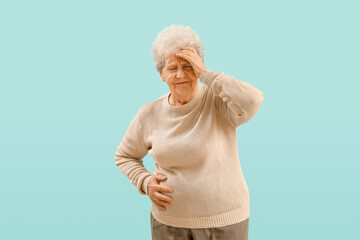 Senior woman with appendicitis on blue background