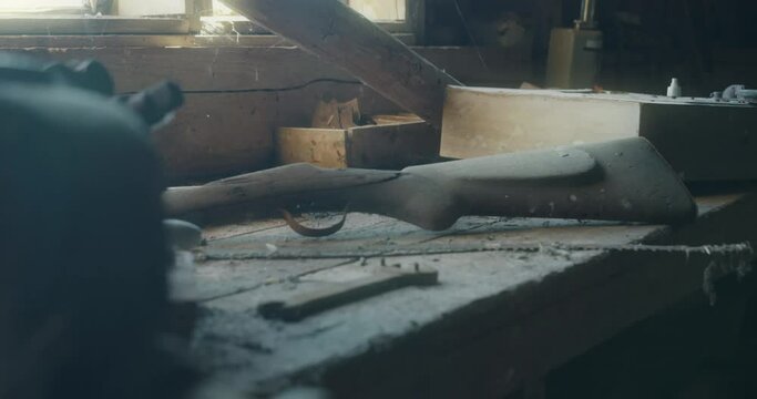 Vintage Hunting Rifle Lies On Old Dust Work Bench in shed, reveal shot