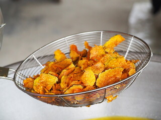 Fried Pumpkin Snacks.Pumpkin slice chips in wooden plate.Closeup topview of fried pumpkin crisp.