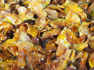 Fried Pumpkin Snacks.Pumpkin slice chips in wooden plate.Closeup topview of fried pumpkin crisp.