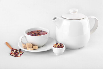 Obraz na płótnie Canvas Teapot and cup of fruit tea with snacks isolated on white background