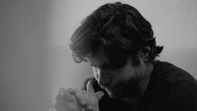 Hopeless 30s man in monochrome despair about future. Dramatic portrayal of young male person's desperation. Young man suffering from depression and alienation