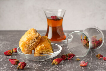Bowl with tasty baklava on grunge background