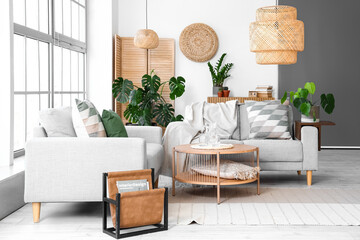 Interior of light living room with sofas and Monstera houseplant © Pixel-Shot