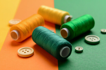 Set of thread spools and buttons on color background