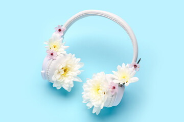 Composition with modern wireless headphones and beautiful chrysanthemum flowers on color background