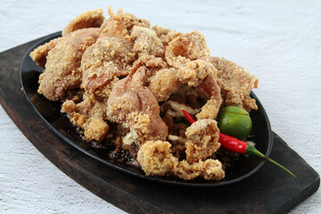 Freshly cooked Filipino food pork sisig topped with fried chicken skin