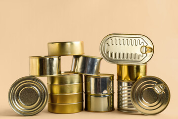 Different tin cans with fish on beige background