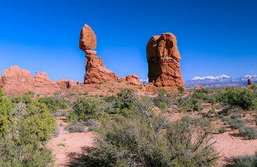 The beautiful rock formation known as the Balanced Rock at the Arches National Park points to the clear blue sky.