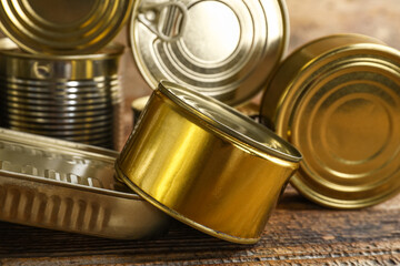 Different tin cans with fish on wooden table