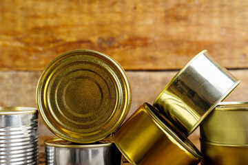 Different tin cans with fish on wooden table