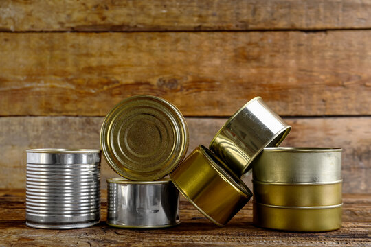 Different tin cans with fish on wooden table