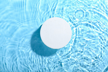 Decorative plaster podium in water on blue background