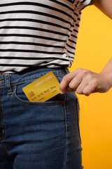 hand of person woman holding plastic credit card out of the pocket blue jean plants isolated on...
