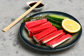 Plate with tasty crab sticks on grunge background © Pixel-Shot