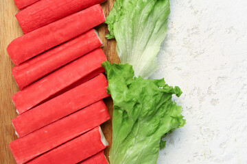 Wooden board with tasty crab sticks on light background, closeup © Pixel-Shot
