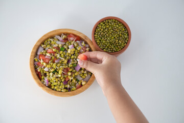 Sprouting green gram bean Indian salad with Onion, coriander leaf , green chili and tomatoes. Indian sprouting gram bean salad kid eating and enjoying