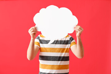 Young man with blank speech bubble on red background