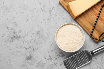 Bowl with tasty grated Parmesan cheese on grunge background