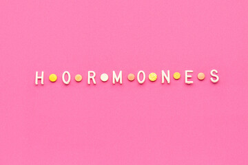 Word HORMONES on pink background