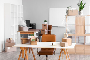 Workplace with cardboard boxes in office on moving day