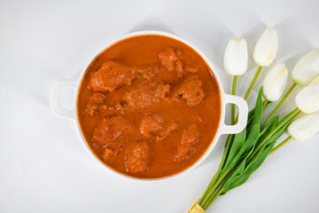 Tasty butter chicken curry dish from Indian cuisine. Tasty butter chicken curry or Murg Makhanwala or masala. Butter chicken tikka masala served with roti / Paratha