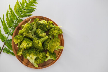 Simple boiled broccoli in a wooden plate and isolated with the white background. Organic boiled broccoli in a wooden plate. Healthy eating concept.