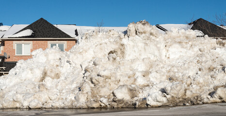 High snow wall in front of town houses