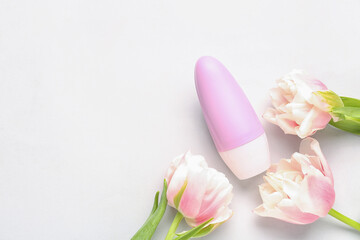 Obraz na płótnie Canvas Deodorant bottle and flowers on white background