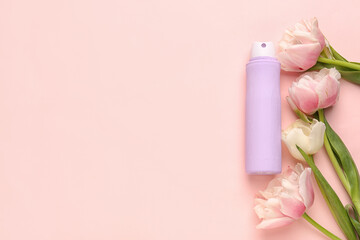 Deodorant bottle and flowers on pink background