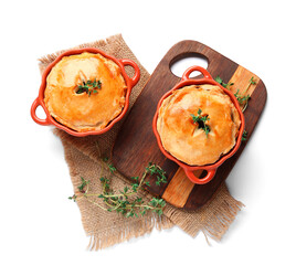 Wooden board with tasty meat pot pies on white background © Pixel-Shot