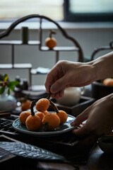 Loquat fruit on the table in architectural interior with oriental charm(Eriobotrya japonica), dark environment, dark tone picture
