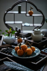 Loquat fruit on the table in architectural interior with oriental charm(Eriobotrya japonica), dark environment, dark tone picture