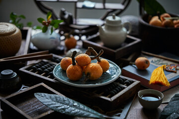 Loquat fruit on the table in architectural interior with oriental charm(Eriobotrya japonica), dark environment, dark tone picture