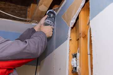 Fototapeta na wymiar Worker cutting drywall plasterboard with using multi tool