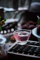 Red bayberry bubble tea on the table(waxberry), in architectural interior with oriental charm, dark environment, dark tone picture