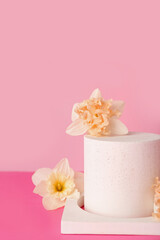 Decorative plaster podiums with flowers on pink background