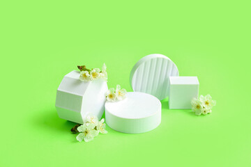 Decorative podiums and white flowers on green background