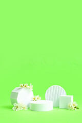 Decorative podiums and white flowers on green background