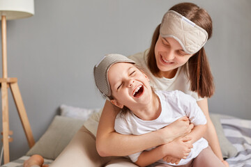 Mother's day. Mommy and her daughter child girl playing and hugging mommy tickling her child...