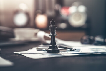 Obraz premium The King in chess pieces and pen are placed on financial documents to signify being the best in business. Abstract business concept.