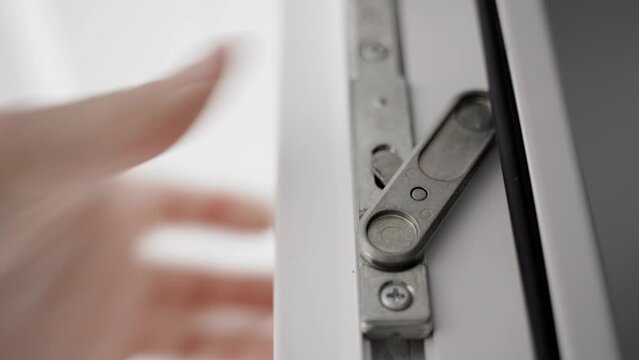 The hand closes the second leaf of plastic doors and blocks the lock, close-up