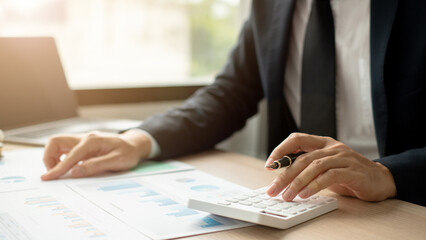 Business man sitting at workplace and using calculators.