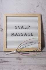 Scalp massager for home with letter board SCALP MASSAGE text. Close up of scalp massaging brush for...
