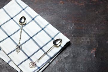 Kitchen table with towel and dessert spoons. Wooden table with a cloth napkin. Above view with copy space, place for text